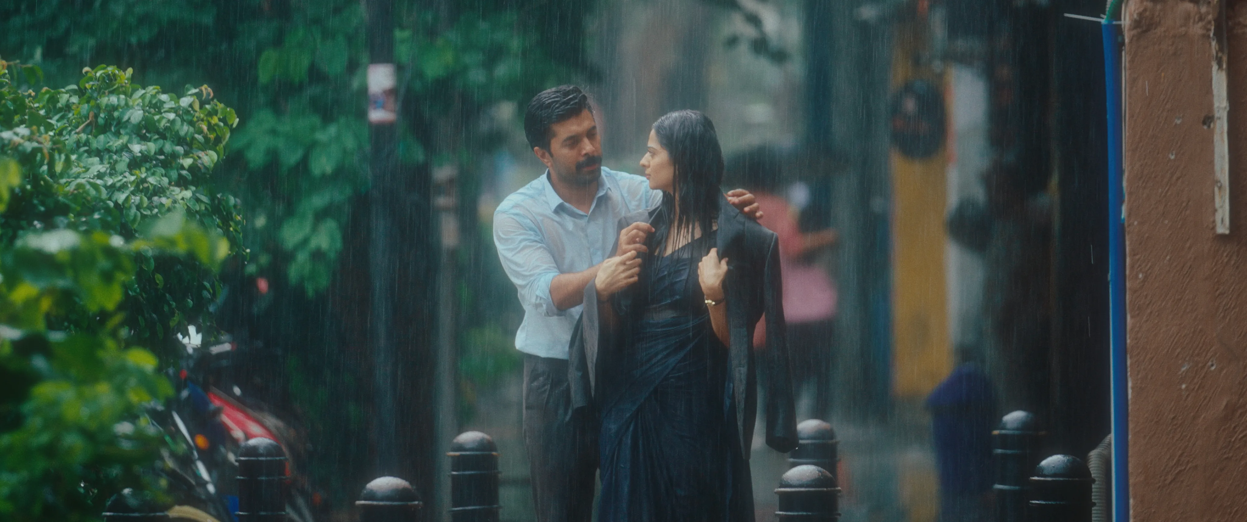 Man and woman walking together along a street in heavy rain.