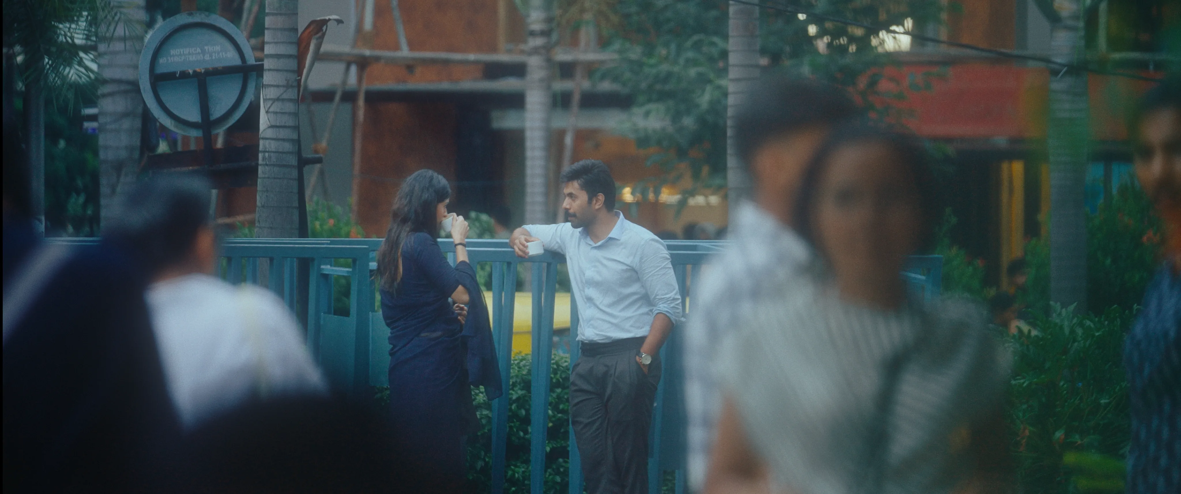 Man and woman talking outside a storefront on a busy street.