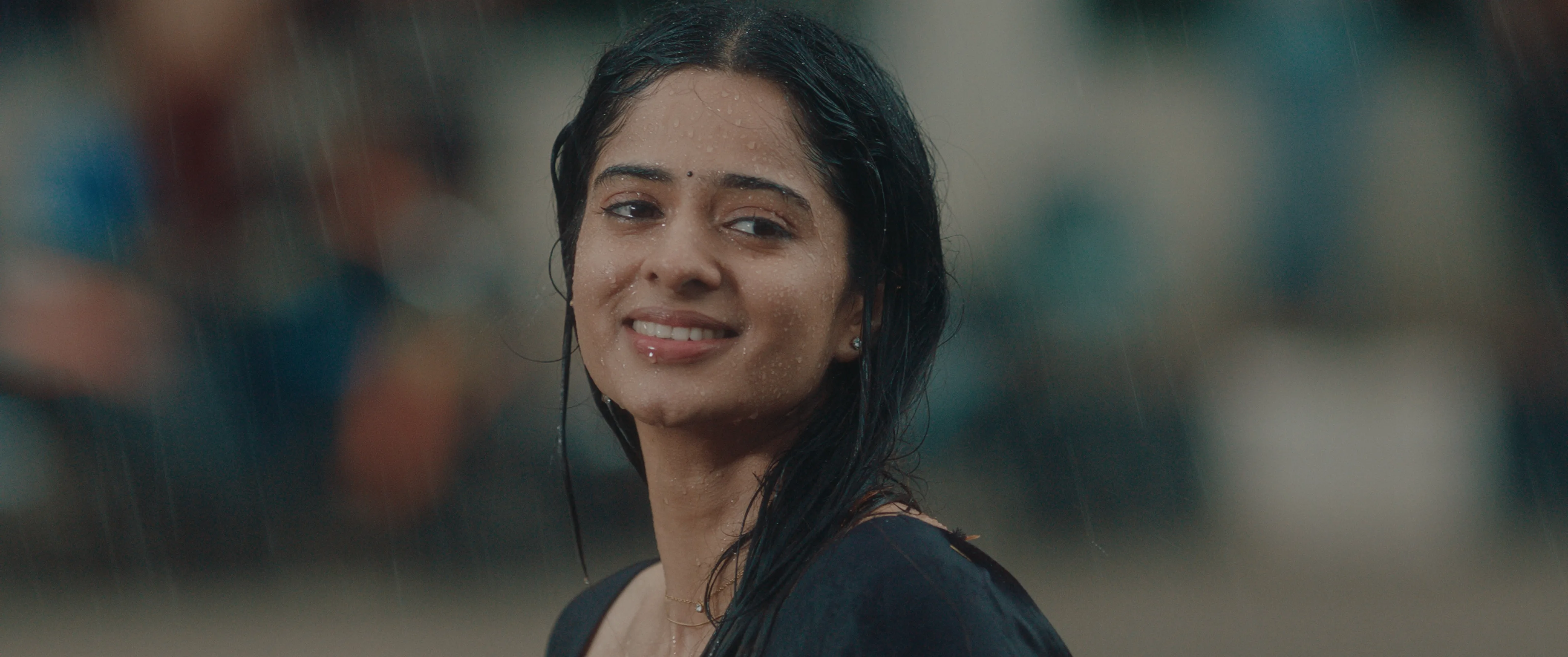 Woman smiling while standing in the rain.