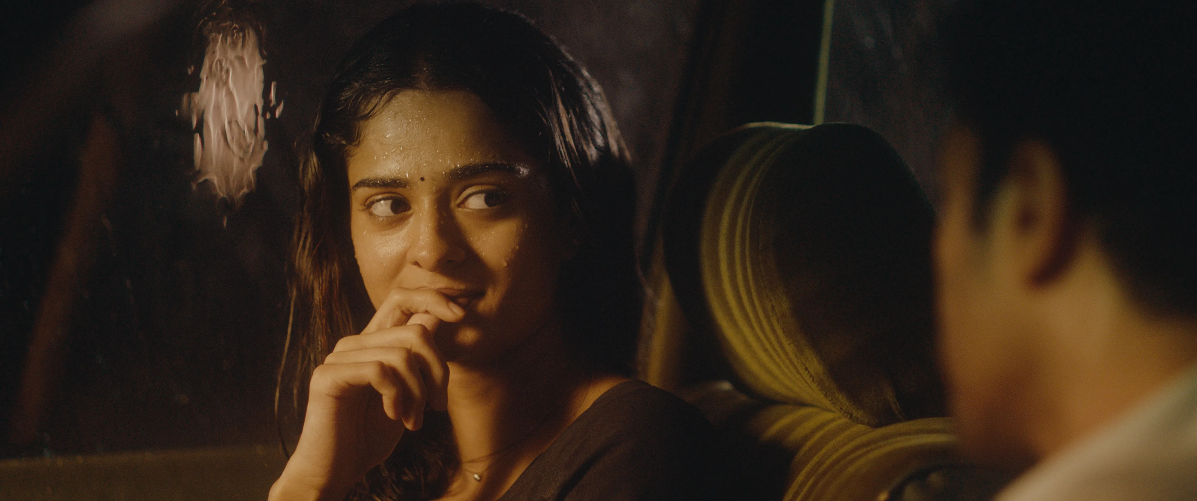 Woman seated inside a car at night, looking toward a man beside her.