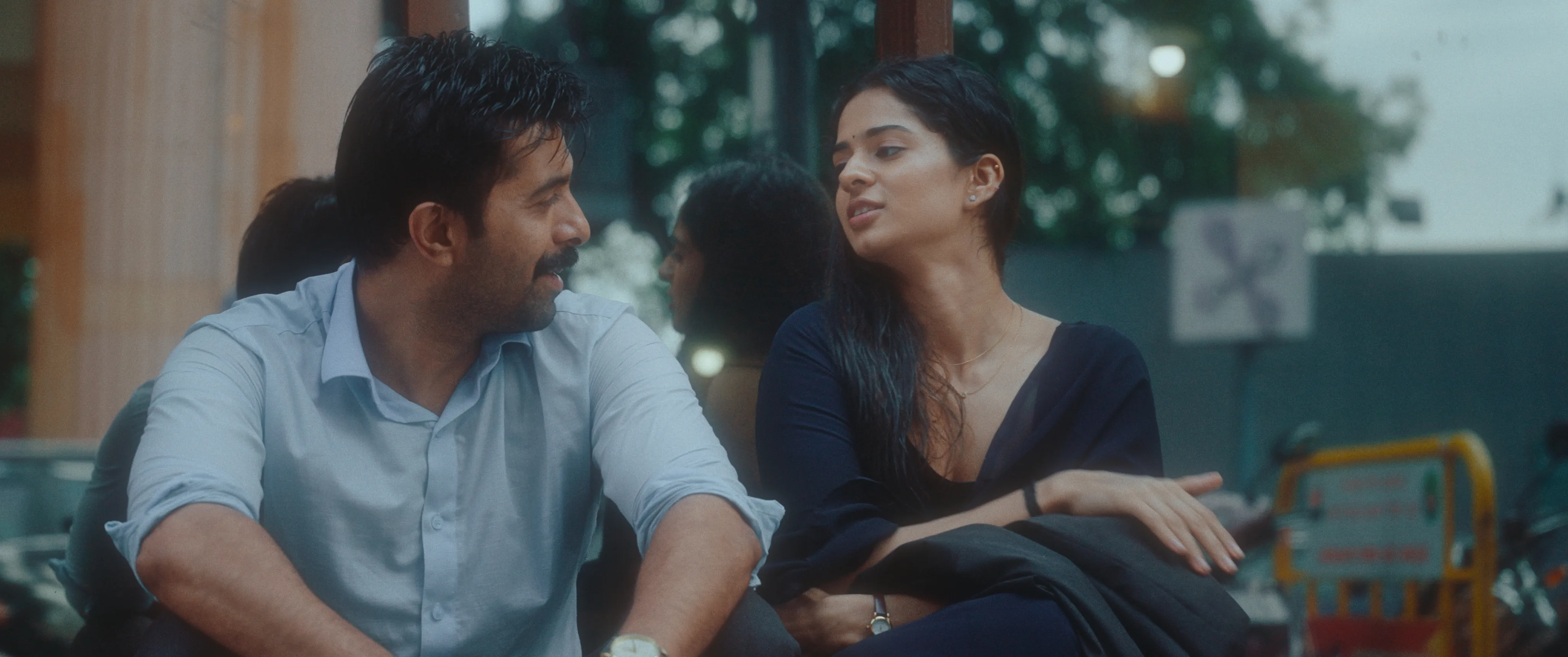 Man and woman sitting closely together and talking outdoors.